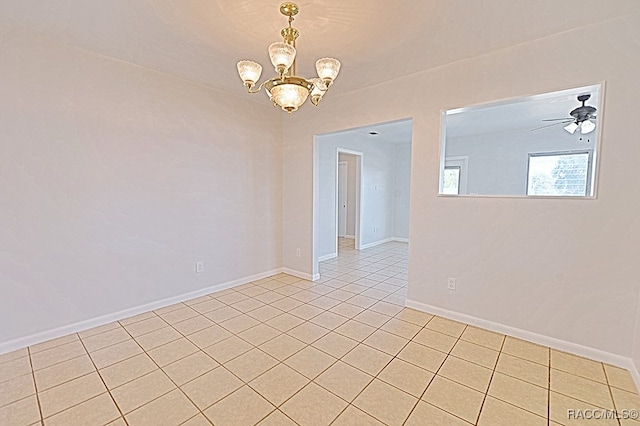 tiled empty room with ceiling fan with notable chandelier