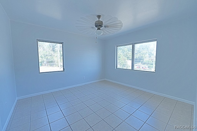 tiled empty room featuring a wealth of natural light and ceiling fan