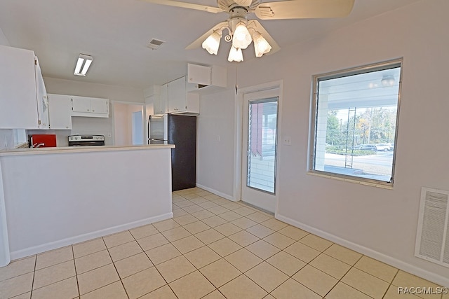 kitchen with kitchen peninsula, stainless steel appliances, ceiling fan, light tile patterned floors, and white cabinetry