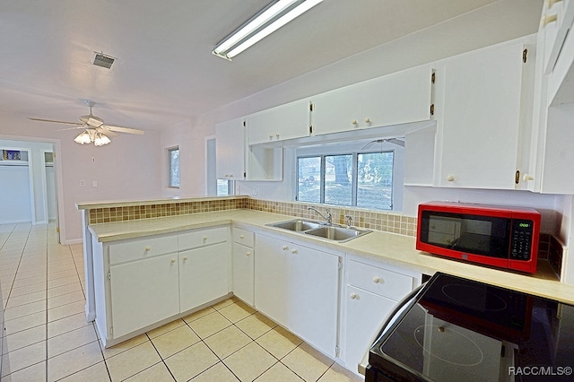 kitchen with white cabinets, range, and sink