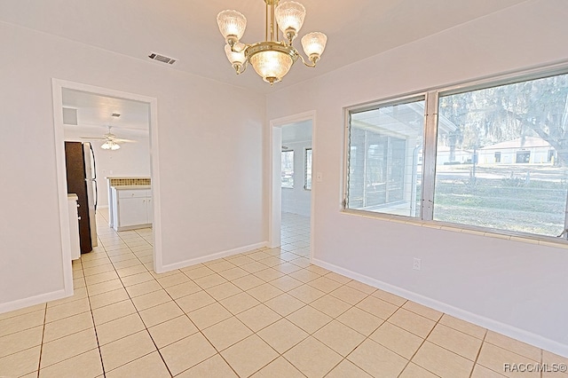 tiled empty room with ceiling fan with notable chandelier