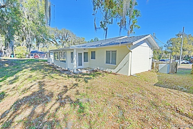 back of property with a lawn and cooling unit