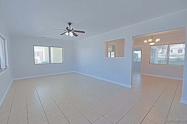 spare room with light tile patterned floors and ceiling fan with notable chandelier