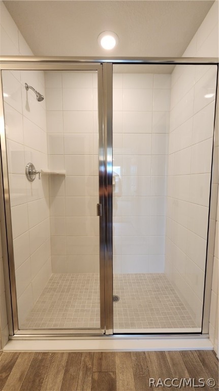 bathroom featuring hardwood / wood-style flooring and a shower with door