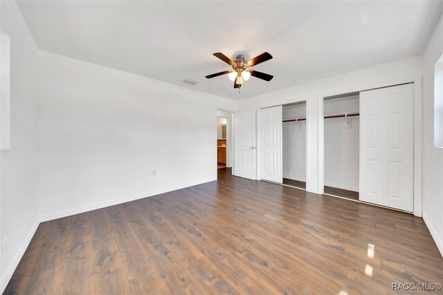 7 N Adams St, Beverly Hills, FL 34465 - unfurnished bedroom with multiple closets, dark wood-style floors, and ceiling fan