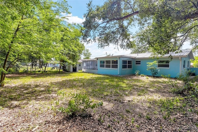 7 N Adams St, Beverly Hills, FL 34465 - rear view of property with a sunroom, a metal roof, and stucco siding