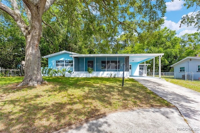 7 N Adams St, Beverly Hills, FL 34465 - view of front facade featuring driveway, an attached carport, and a sunroom