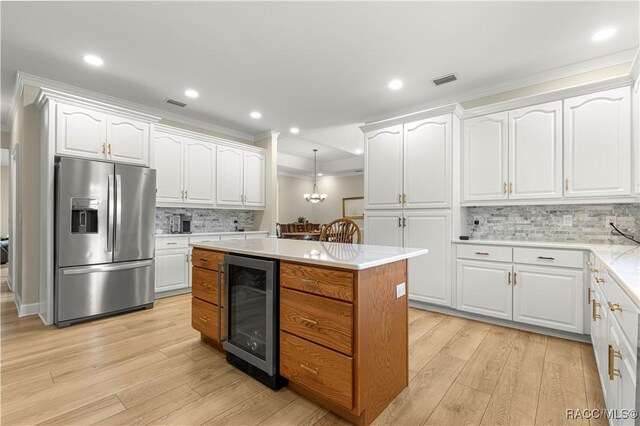 1200 N Annapolis Ave, Hernando, FL 34442 - kitchen featuring stainless steel fridge with ice dispenser, beverage cooler, ornamental molding, light wood-type flooring, and white cabinets
