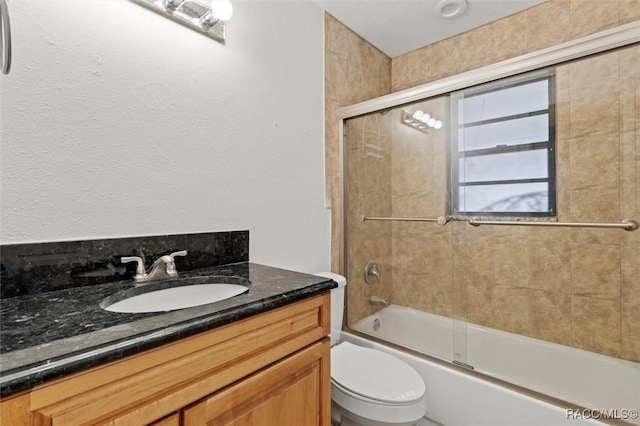 full bathroom featuring toilet, vanity, and bath / shower combo with glass door