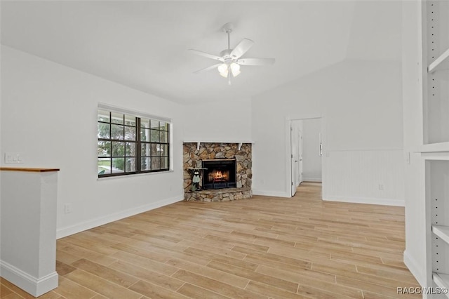 unfurnished living room with ceiling fan, lofted ceiling, light wood-type flooring, and a fireplace