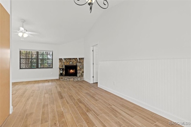 unfurnished living room with ceiling fan, a fireplace, and light hardwood / wood-style flooring