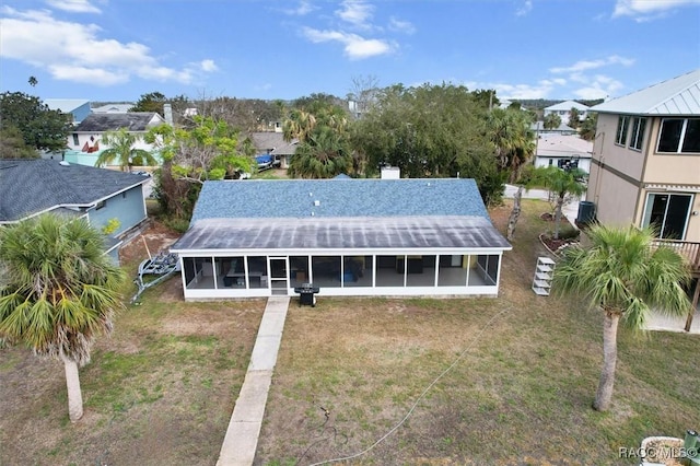 exterior space with a sunroom and a lawn