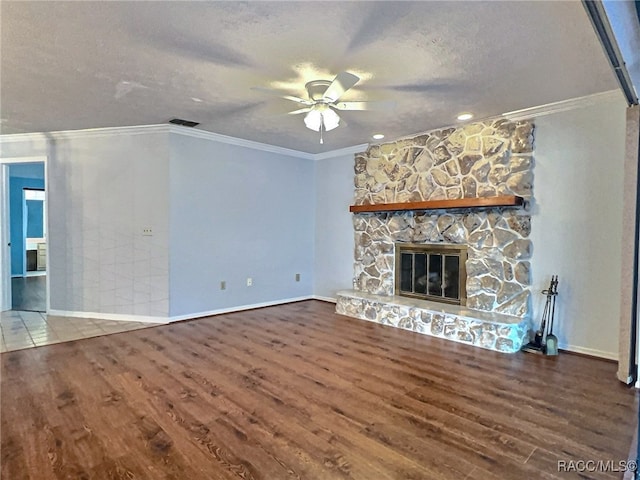 unfurnished living room with crown molding, hardwood / wood-style flooring, ceiling fan, a fireplace, and a textured ceiling