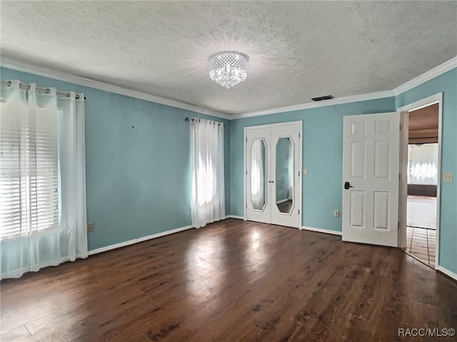 unfurnished room with french doors, dark hardwood / wood-style floors, a notable chandelier, crown molding, and a textured ceiling