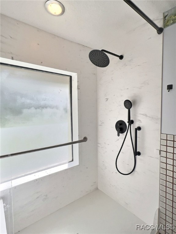 bathroom with walk in shower and concrete floors