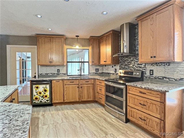 kitchen featuring sink, wall chimney exhaust hood, pendant lighting, double oven range, and decorative backsplash