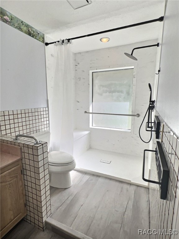 bathroom featuring toilet, hardwood / wood-style floors, and walk in shower