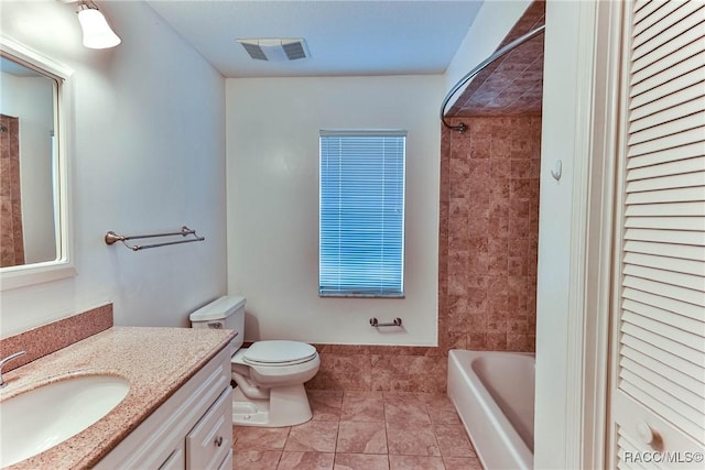 full bathroom with toilet, vanity, tiled shower / bath, and tile patterned flooring