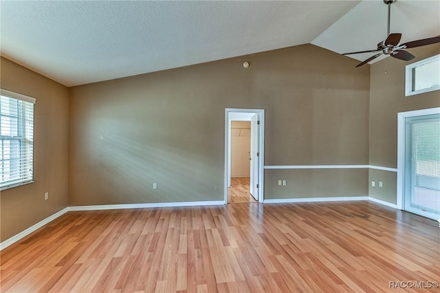 spare room featuring ceiling fan, light hardwood / wood-style floors, and lofted ceiling