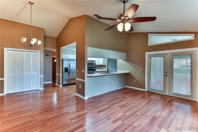 kitchen featuring kitchen peninsula, light hardwood / wood-style floors, pendant lighting, and appliances with stainless steel finishes