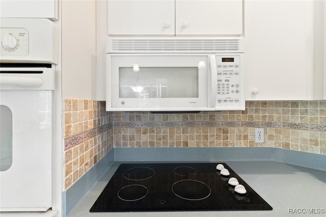details featuring white cabinets, backsplash, and white appliances
