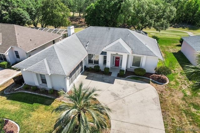 view of front of property with a garage, a front yard, roof with shingles, stucco siding, and driveway