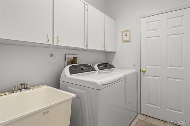 washroom featuring a sink, cabinet space, and independent washer and dryer