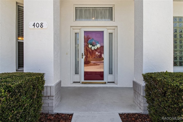 view of exterior entry featuring stucco siding
