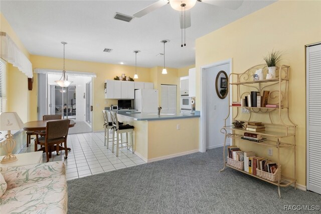 408 W Crestmont Ct, Beverly Hills, FL 34465 - kitchen featuring a breakfast bar, white appliances, a ceiling fan, white cabinetry, and visible vents