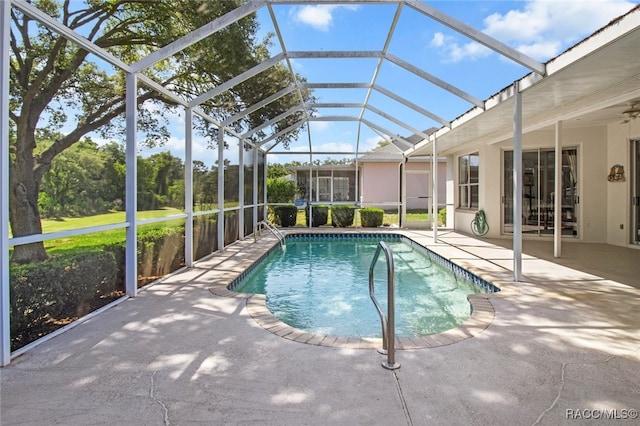 pool with glass enclosure, ceiling fan, and a patio area