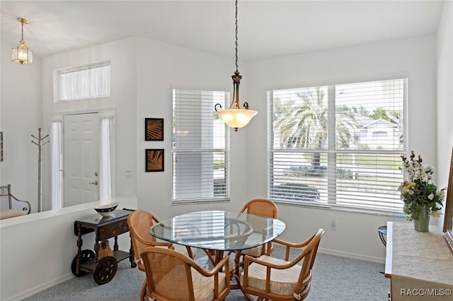carpeted dining area featuring baseboards and plenty of natural light