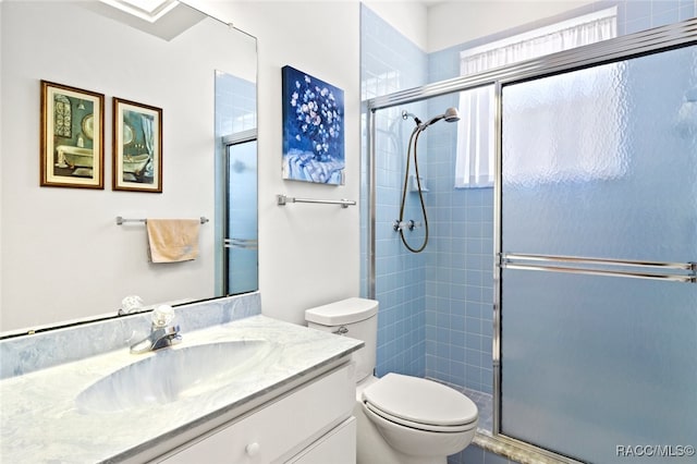 full bath with vanity, toilet, and a shower stall