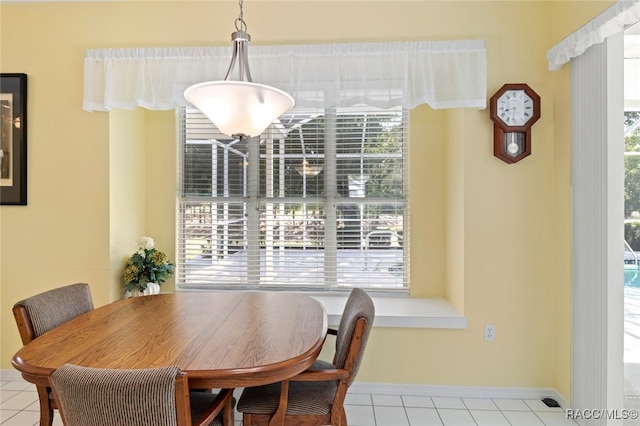 tiled dining area with baseboards and plenty of natural light