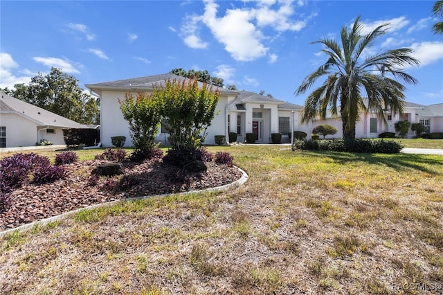 view of front of home featuring stucco siding and a front yard
