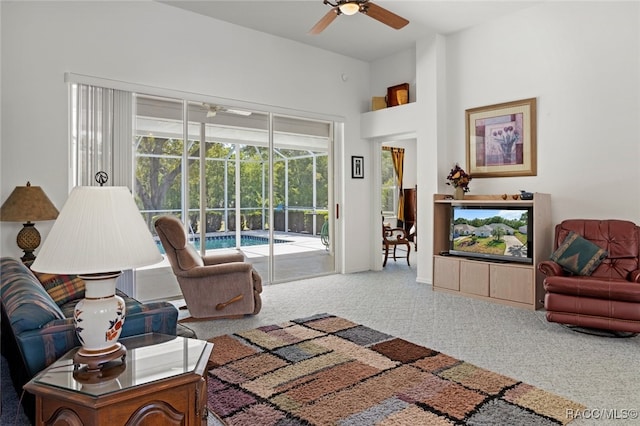 carpeted living room with ceiling fan and a sunroom