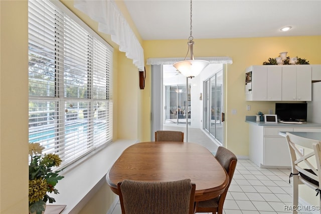 dining area with baseboards, light tile patterned flooring, and a wealth of natural light