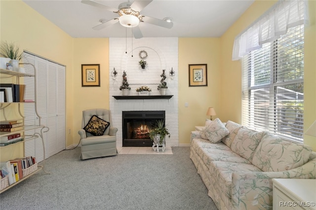 carpeted living room featuring baseboards, ceiling fan, and a fireplace