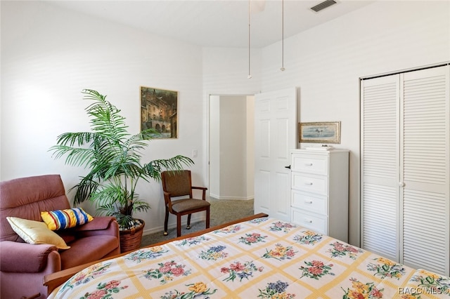 bedroom with a high ceiling, carpet, baseboards, visible vents, and a closet