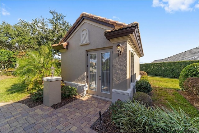 back of property with a yard and french doors