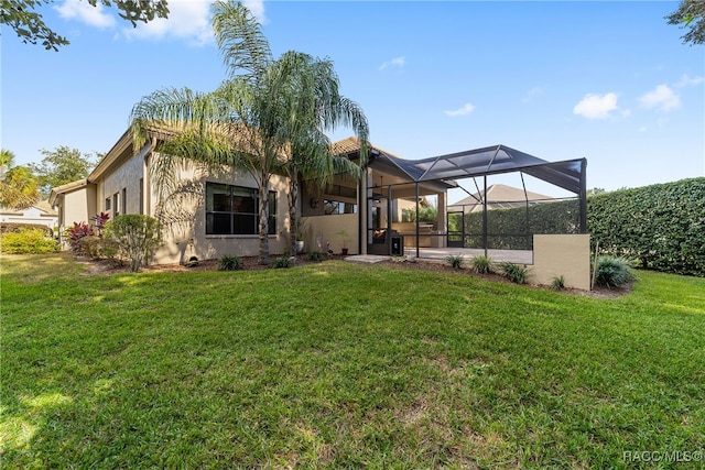 back of property with a yard and a lanai