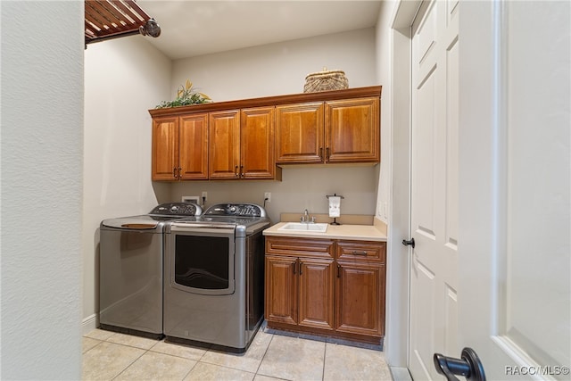 clothes washing area with cabinets, sink, separate washer and dryer, and light tile patterned flooring