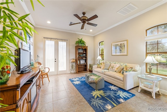 tiled living room with plenty of natural light, ceiling fan, crown molding, and french doors