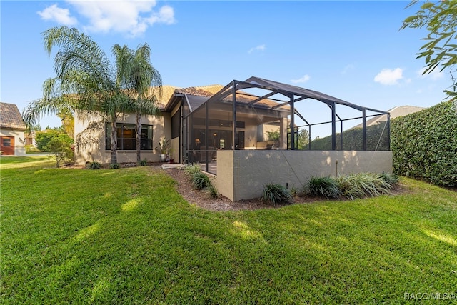 rear view of house with a lawn and a lanai