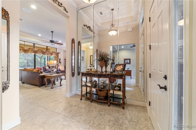 interior space with ornamental molding, a raised ceiling, ceiling fan, pendant lighting, and light tile patterned flooring