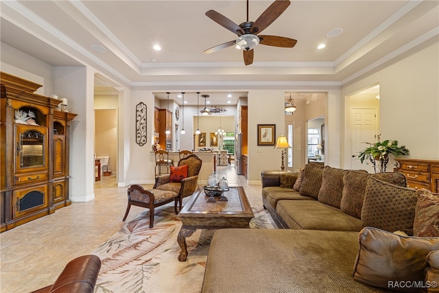 living room featuring light tile patterned floors, a raised ceiling, ceiling fan, and ornamental molding