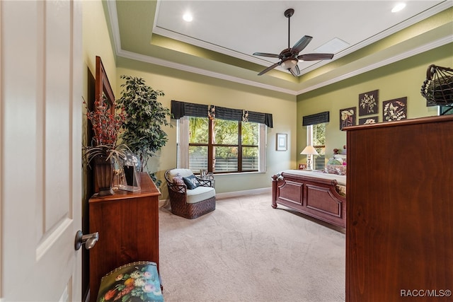 bedroom featuring a raised ceiling, light carpet, ceiling fan, and ornamental molding