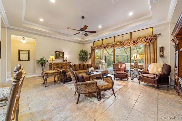 living room with ceiling fan, light tile patterned flooring, a raised ceiling, and crown molding