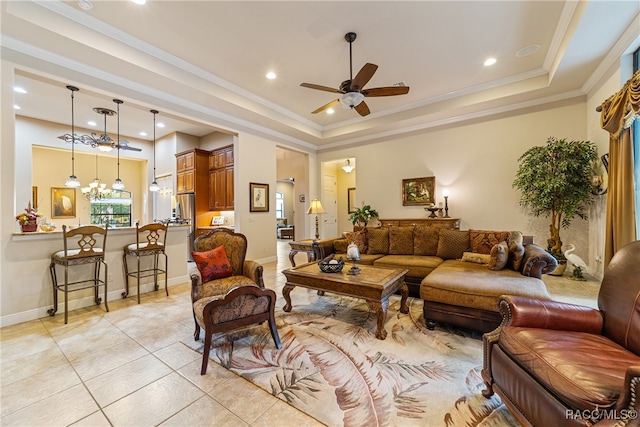 tiled living room featuring ceiling fan with notable chandelier, a tray ceiling, and ornamental molding