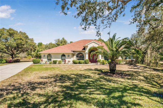 mediterranean / spanish-style home featuring a front yard, concrete driveway, and stucco siding