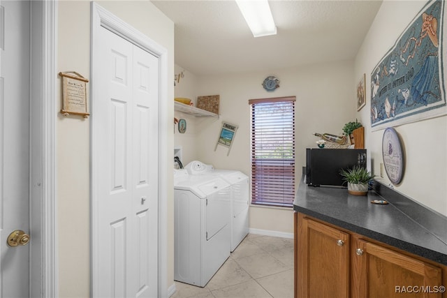 clothes washing area featuring laundry area, light tile patterned floors, baseboards, and independent washer and dryer